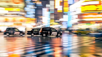 A vibrant cityscape with delivery vehicles on the move.