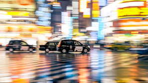 Night cityscape with multiple taxis moving smoothly on illuminated roads.