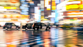 Night cityscape with multiple taxis moving smoothly on illuminated roads.