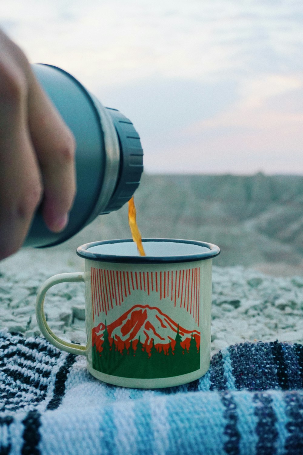 Taza de cerámica roja y blanca sobre textil blanco y negro