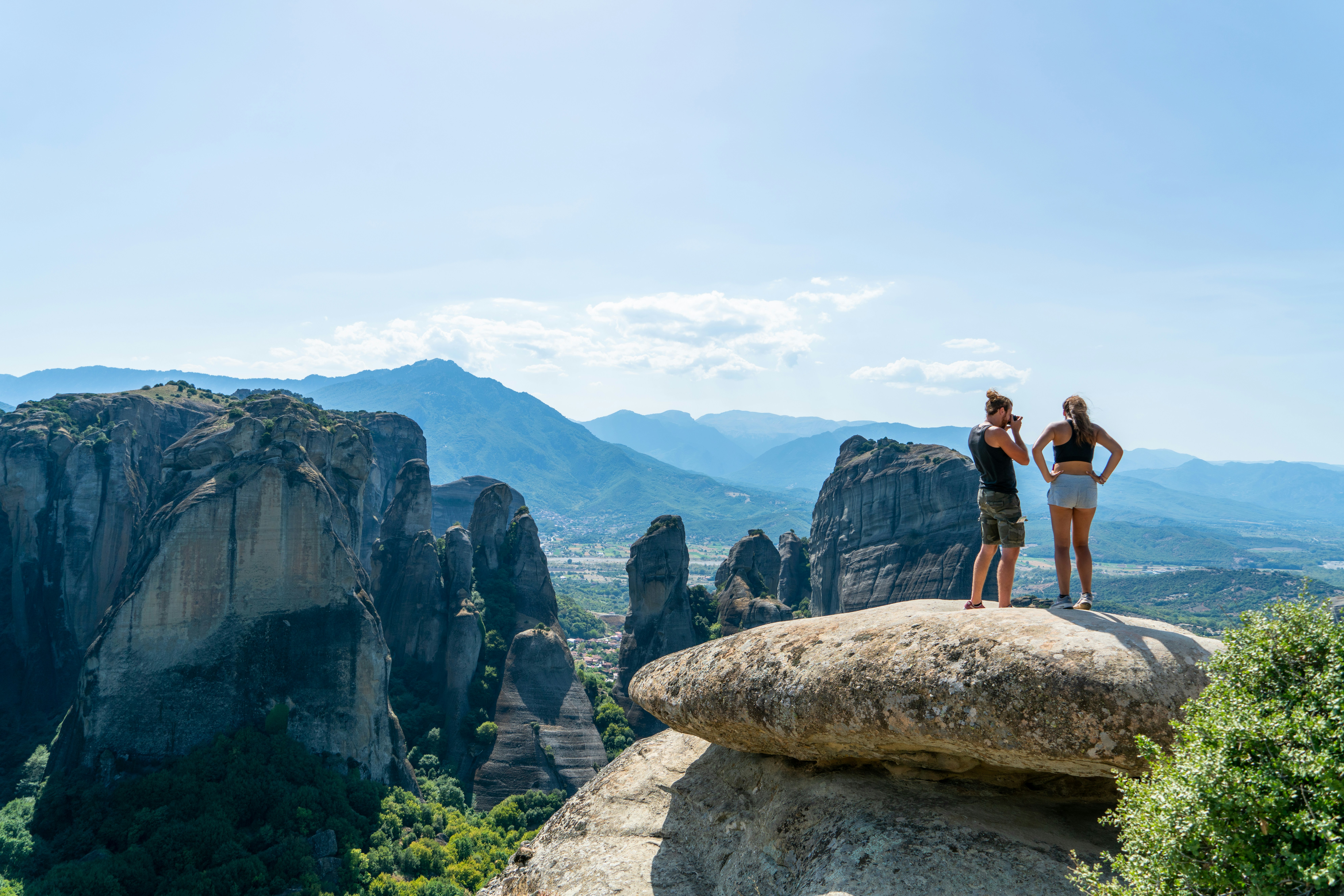 man and woman standing on rock formation during daytime