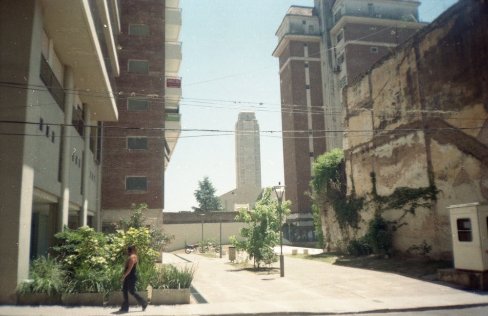 woman in black jacket walking on sidewalk during daytime