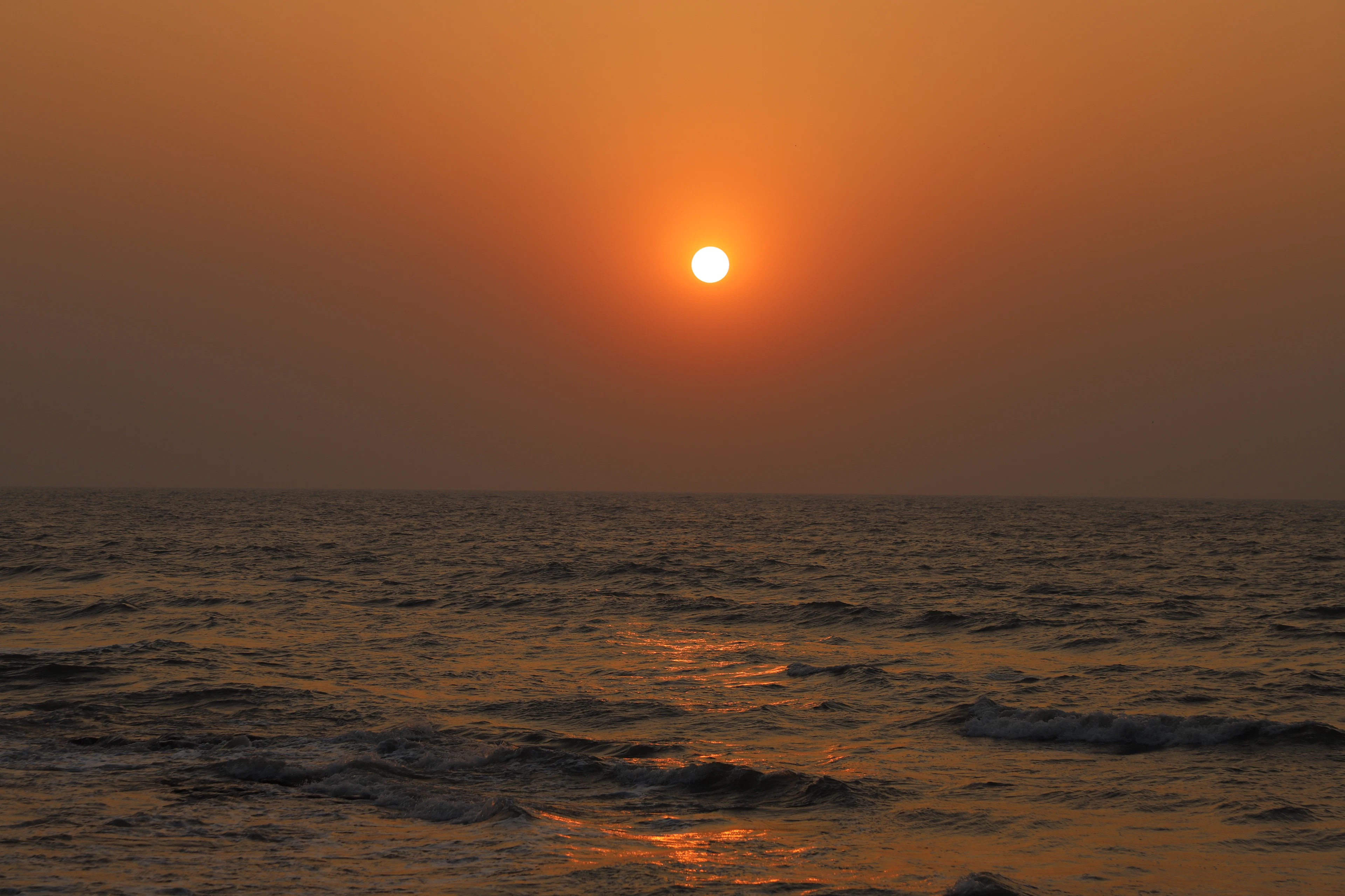 Waves breaking on the shore at sunset