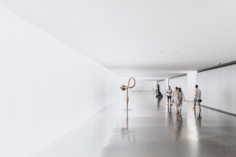 people walking on white hallway