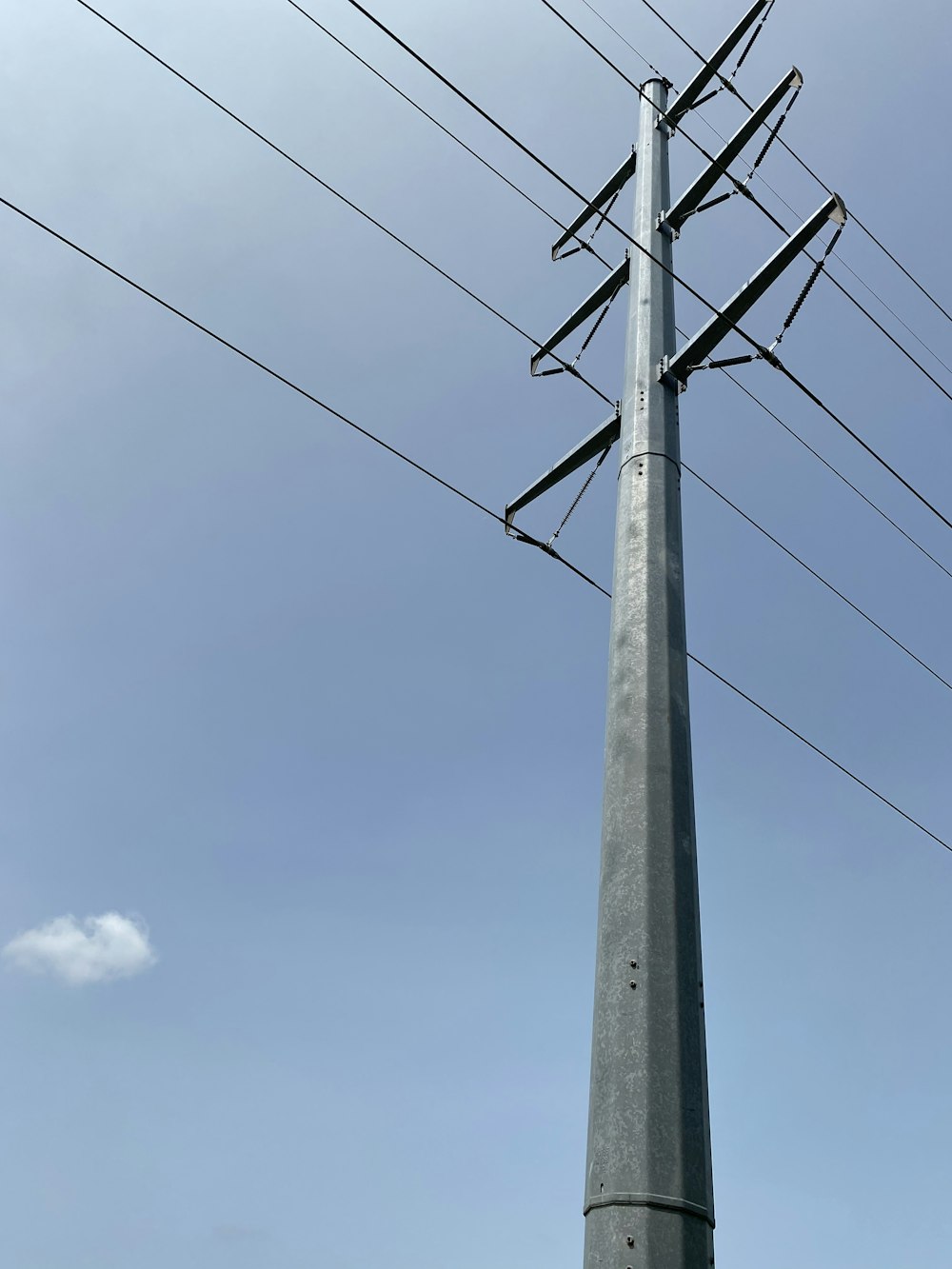 gray electric post under blue sky during daytime