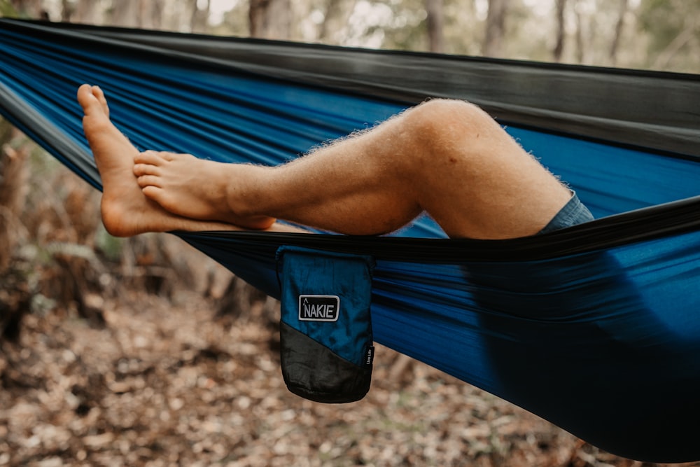 person lying on blue hammock