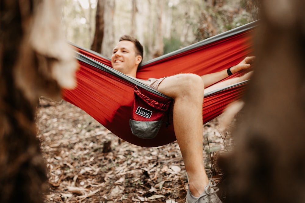 woman in red tank top lying on red hammock