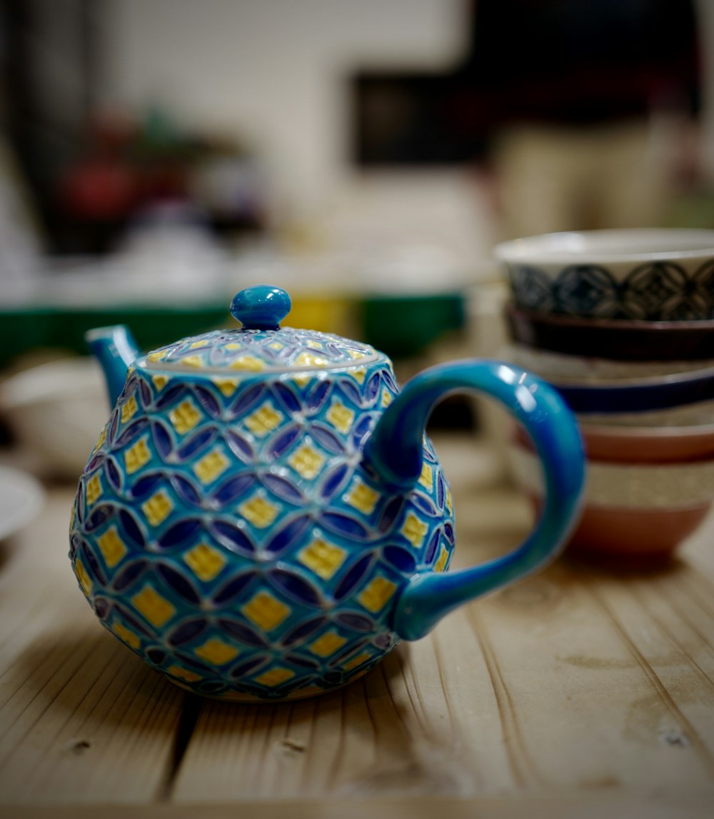 blue and white ceramic teapot on brown wooden table