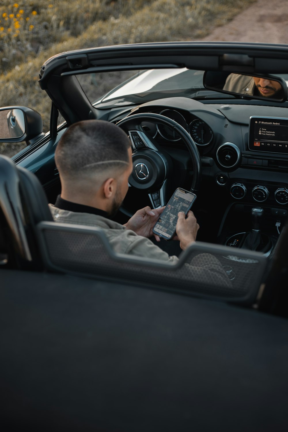 man in black jacket holding smartphone