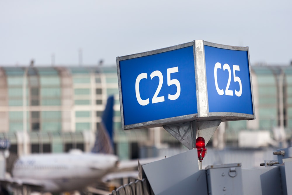 um grande sinal azul sentado em cima de uma pista do aeroporto