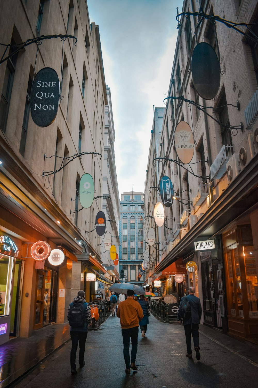 people walking on street between buildings during daytime