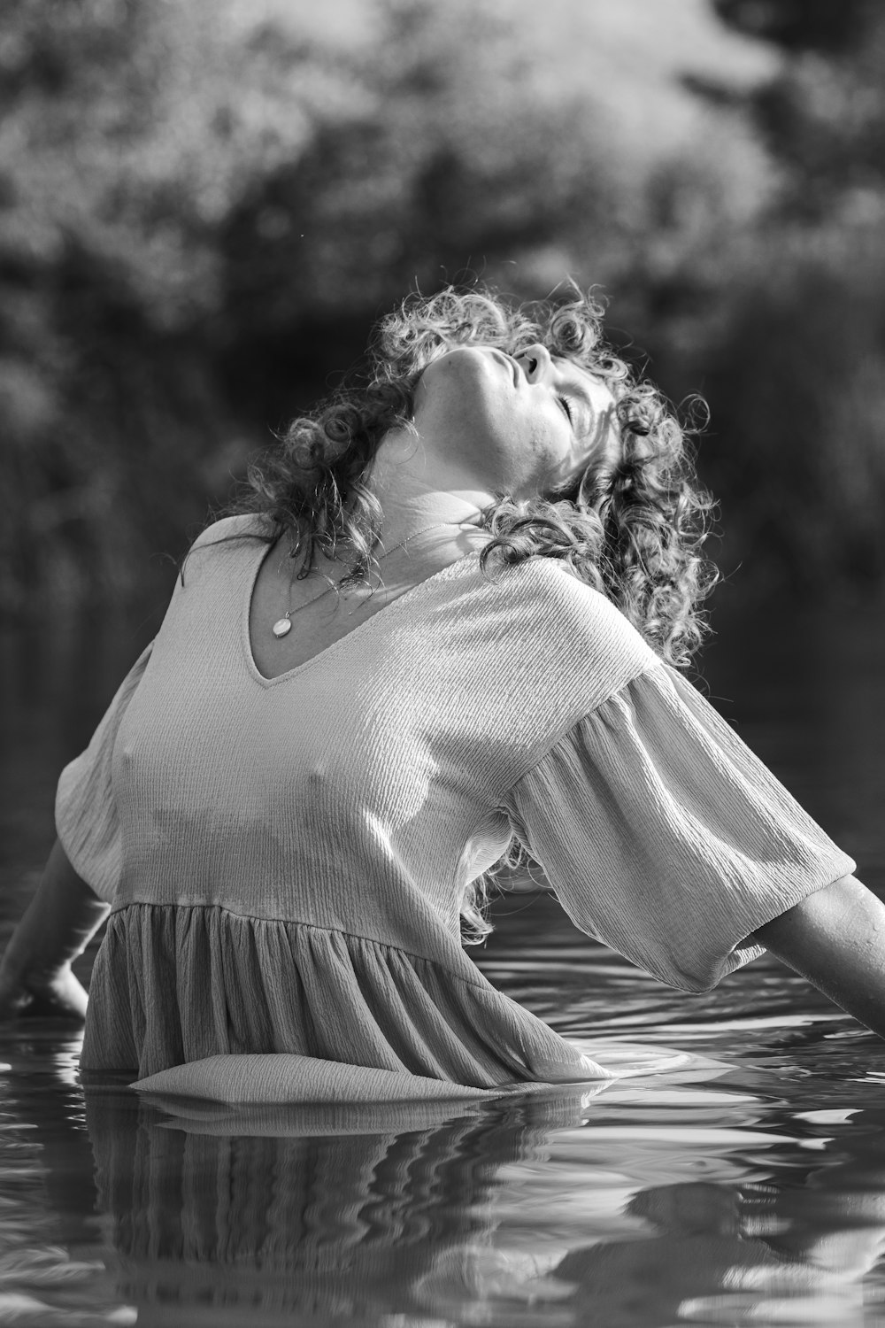 woman in white long sleeve shirt and black skirt standing on water