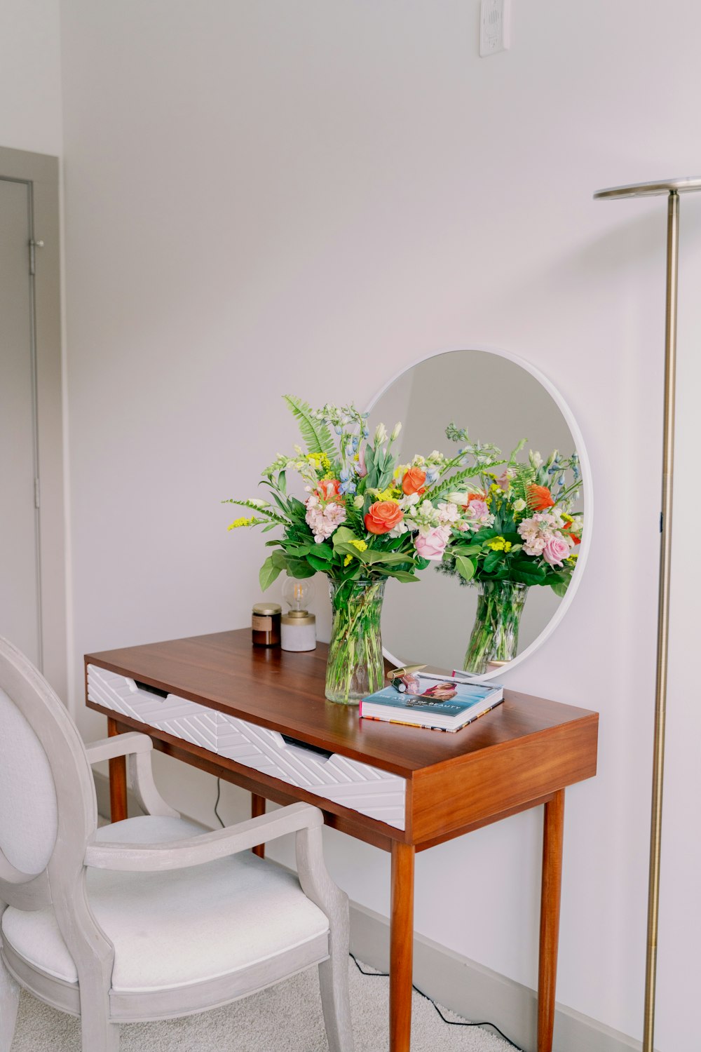 white and red flowers in clear glass vase on brown wooden table