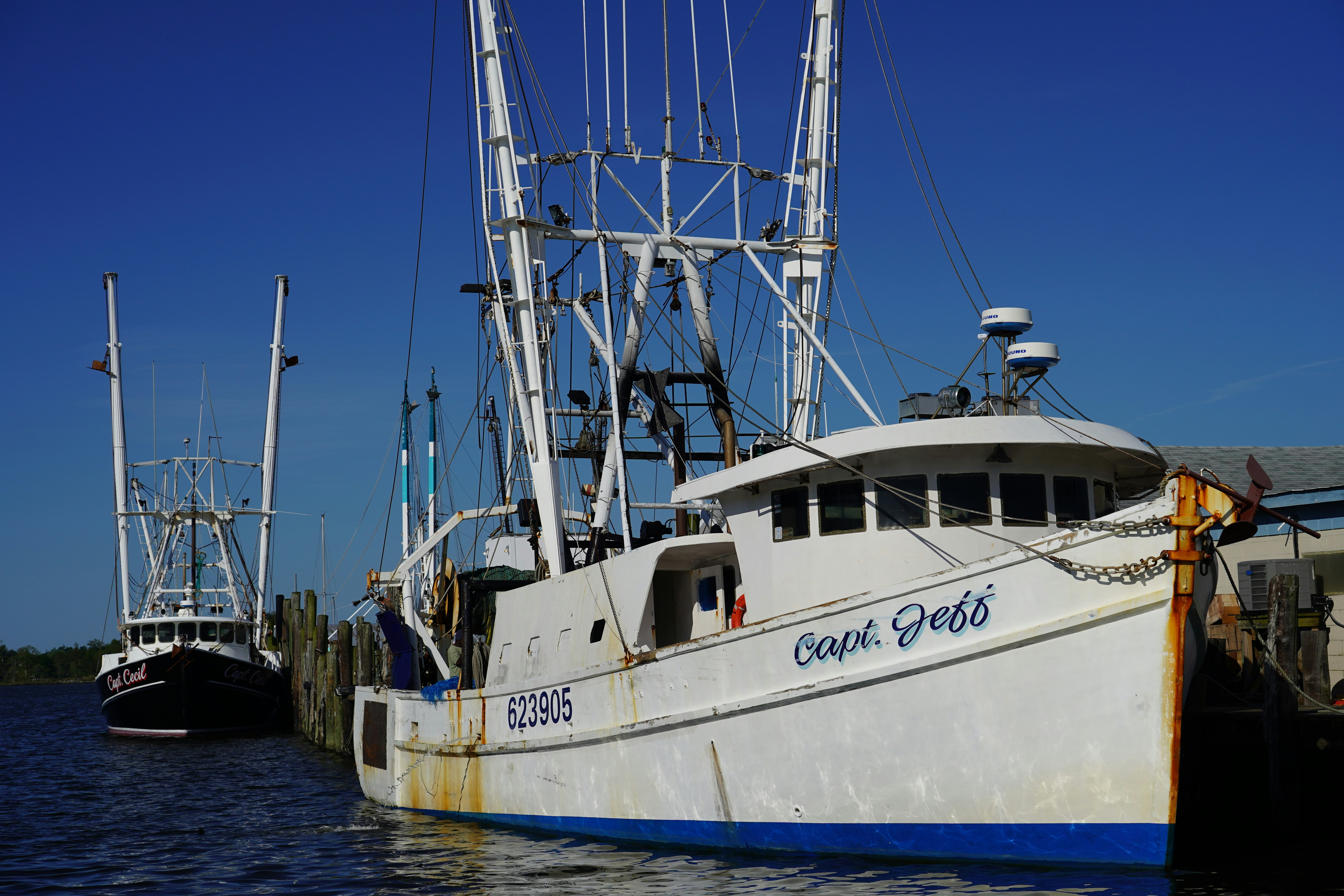 white and black boat on sea dock during daytime