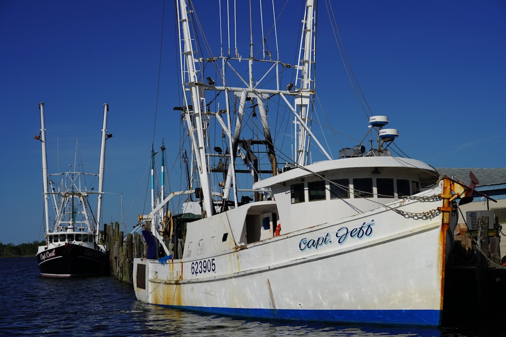 white and black boat on sea dock during daytime