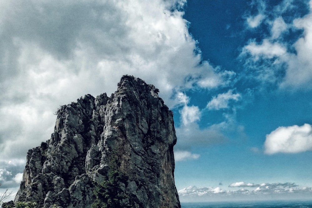 gray rock formation under blue sky and white clouds during daytime