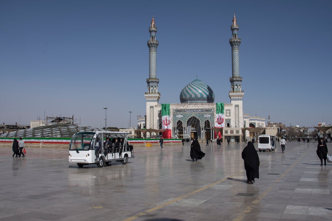 people walking near white and green mosque during daytime