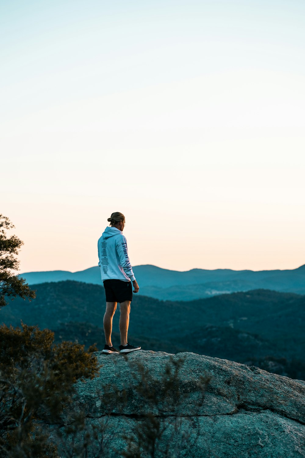 man in blue shirt standing on rock formation during daytime