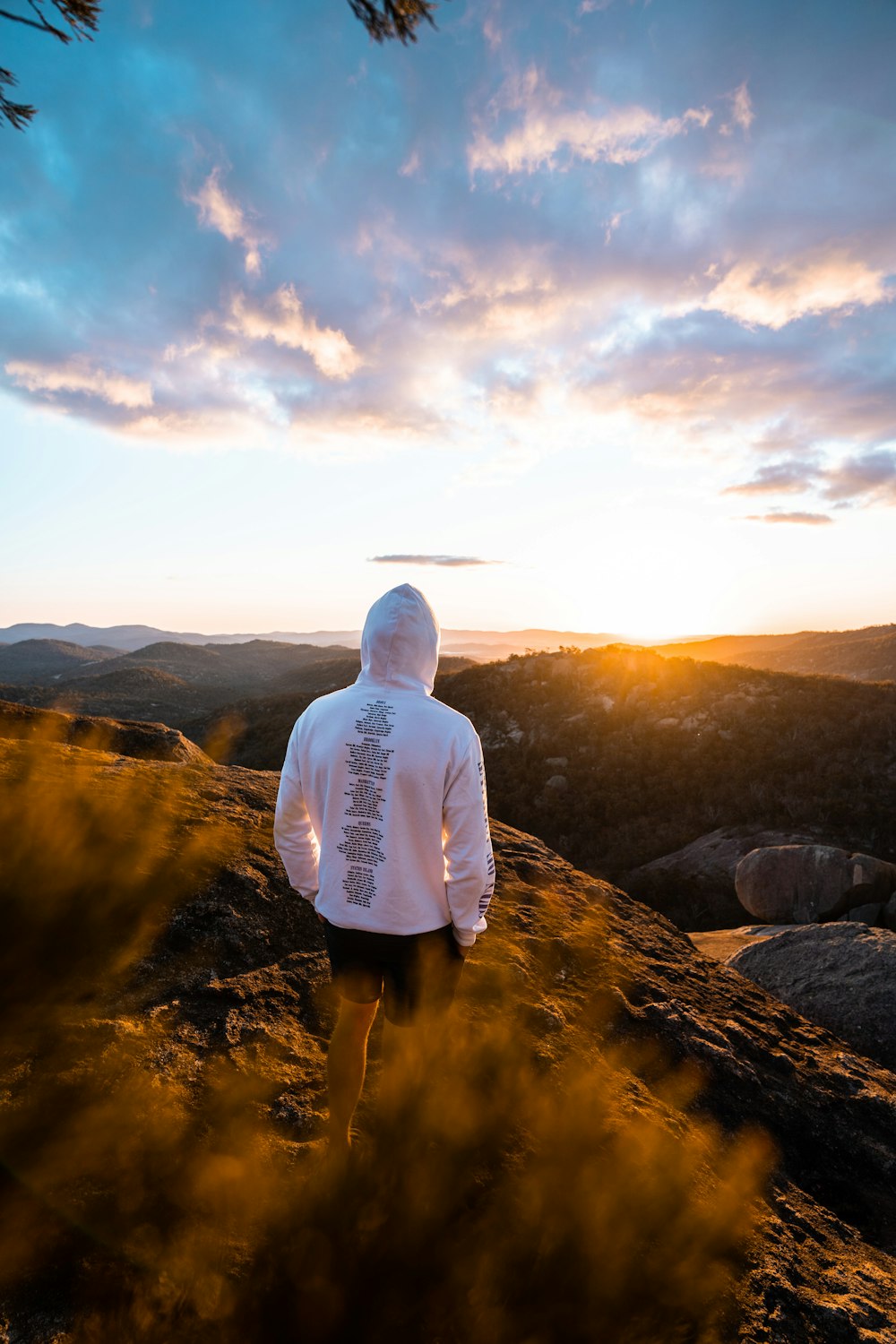 man in white shirt standing on rock formation during daytime