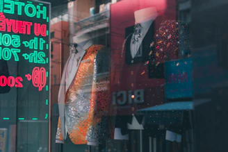 Stylish men’s and women’s fashion outfits displayed on mannequins with subtle green and gold accents reflecting Pakistani culture.