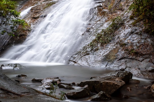 water falls on rocky shore during daytime in Gabai River Malaysia