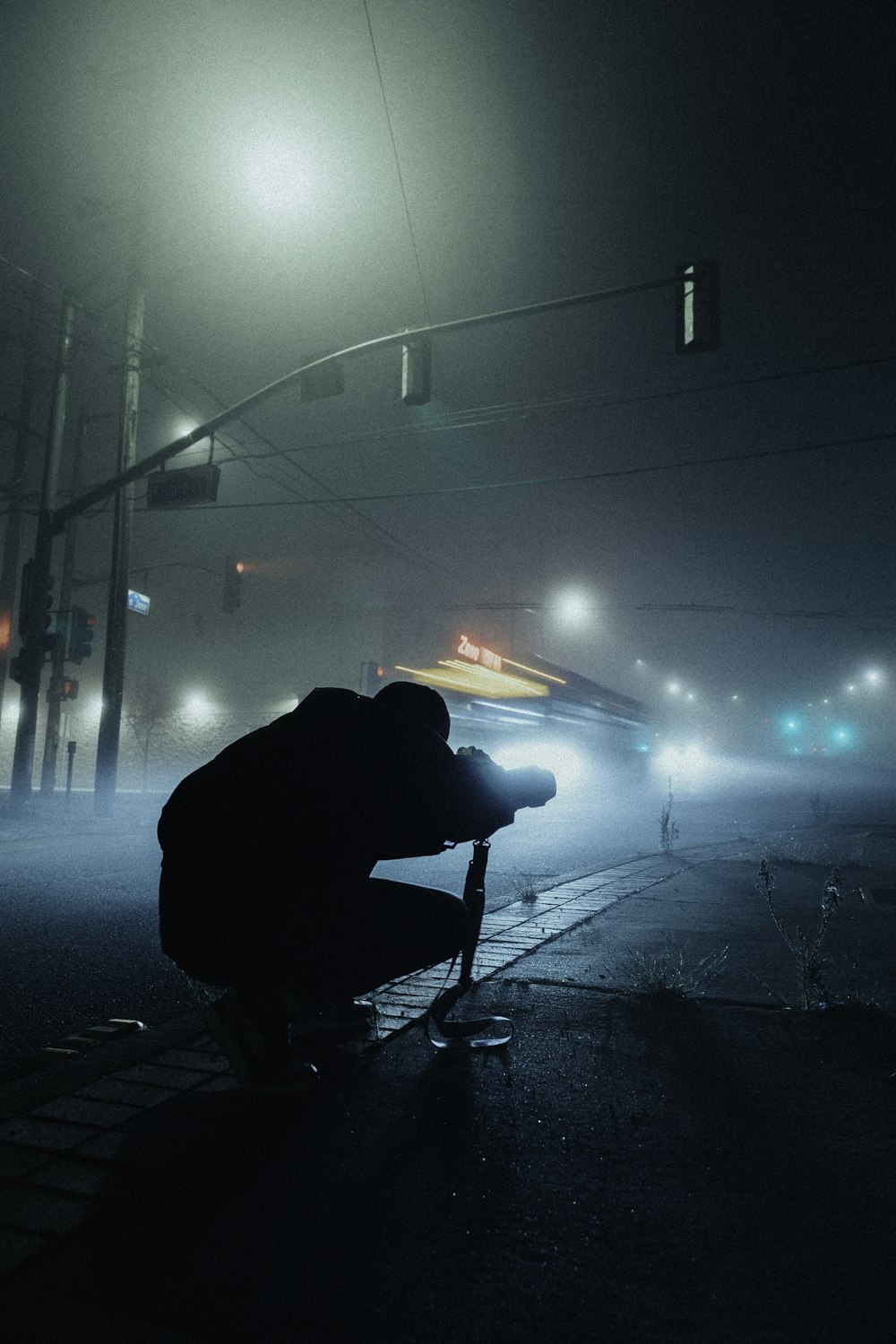 a person kneeling down on a street at night