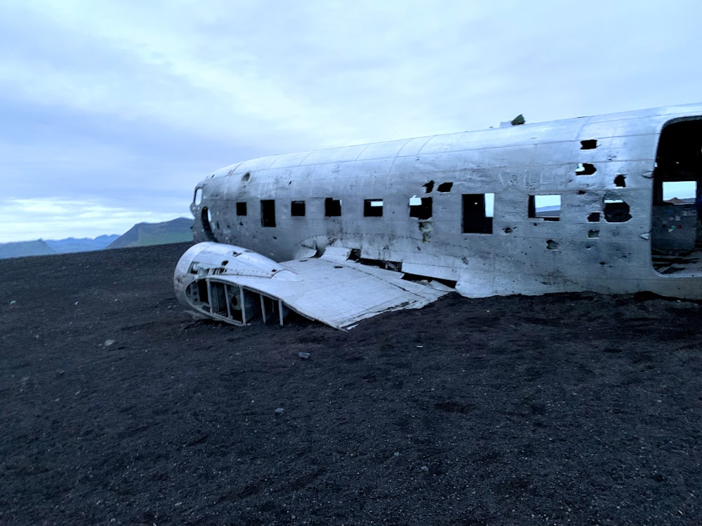 white and black airplane on gray sand during daytime