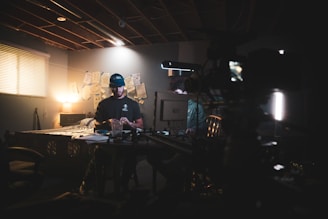 A discreet investigator reviewing surveillance footage on a laptop in a dimly lit room.