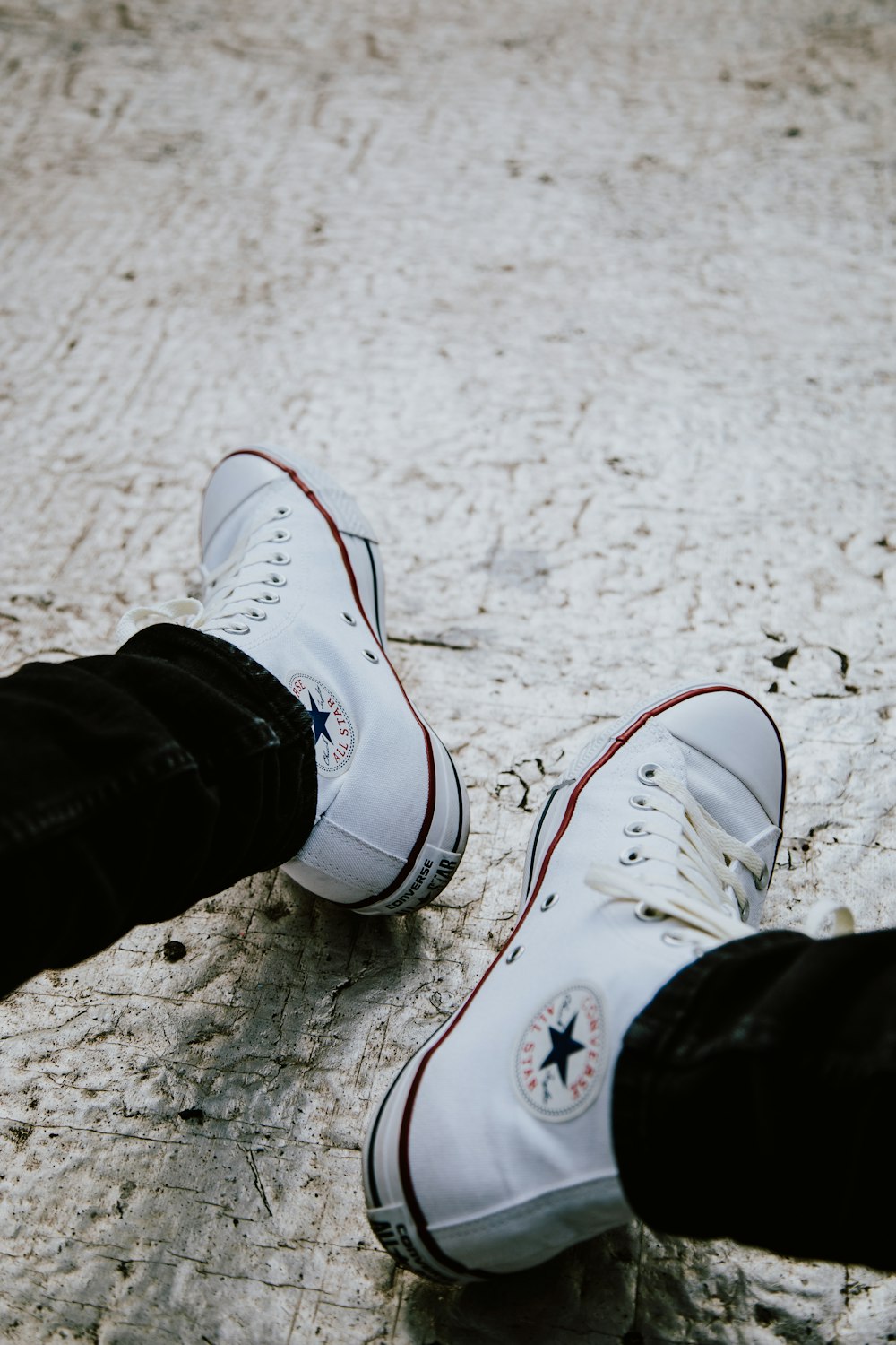 person wearing white converse all star high top sneakers