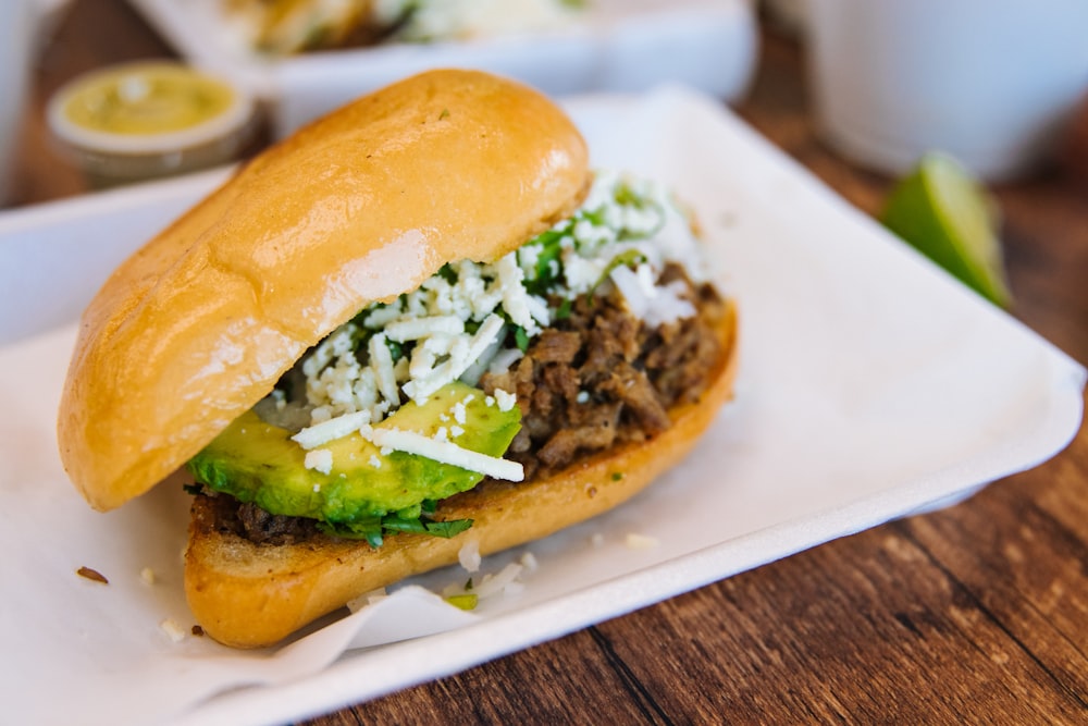 Un primer plano de un sándwich en un plato sobre una mesa