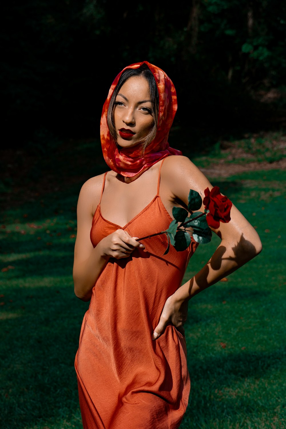 woman in red hijab holding red rose