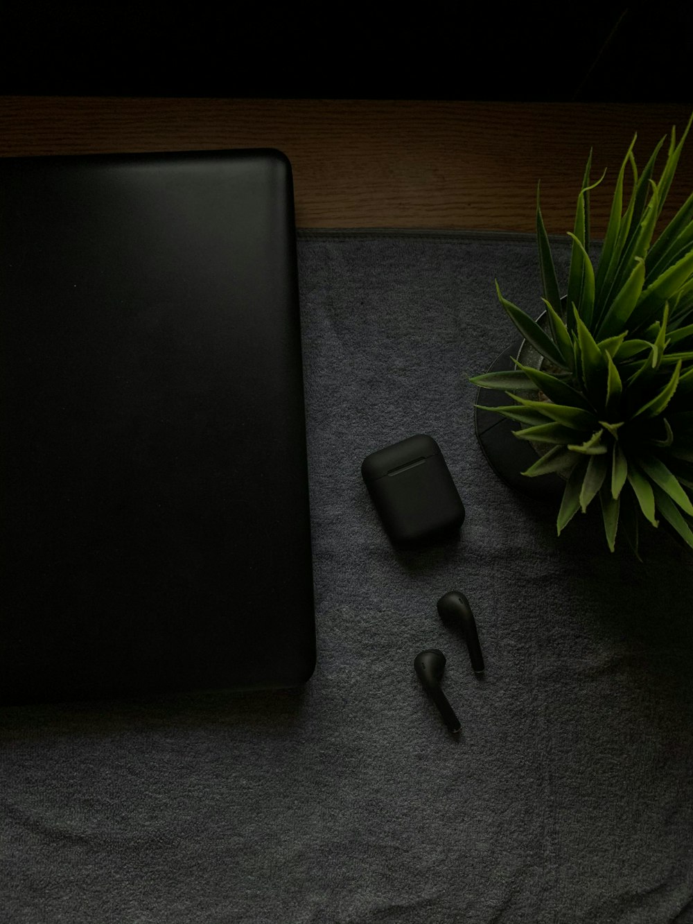 black bluetooth earbuds beside black laptop computer