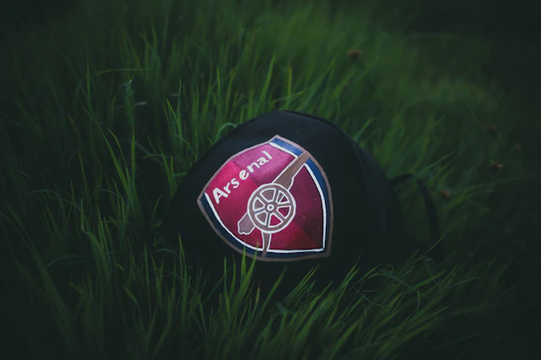 Close-up of an Arsenal home jersey with vibrant red and white colors displayed on a wooden table.