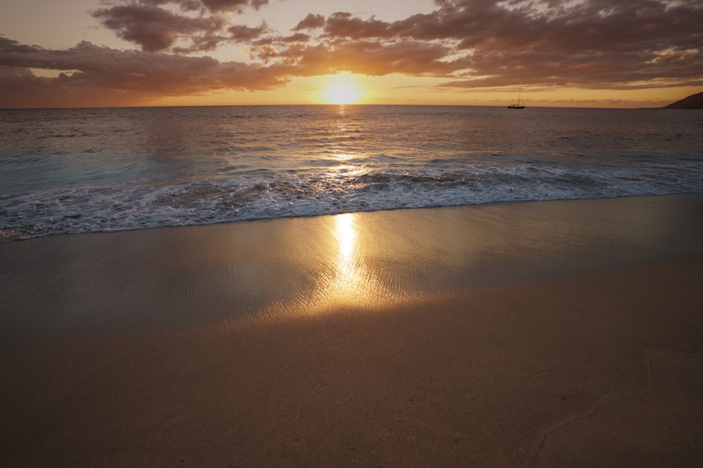 sea waves crashing on shore during sunset