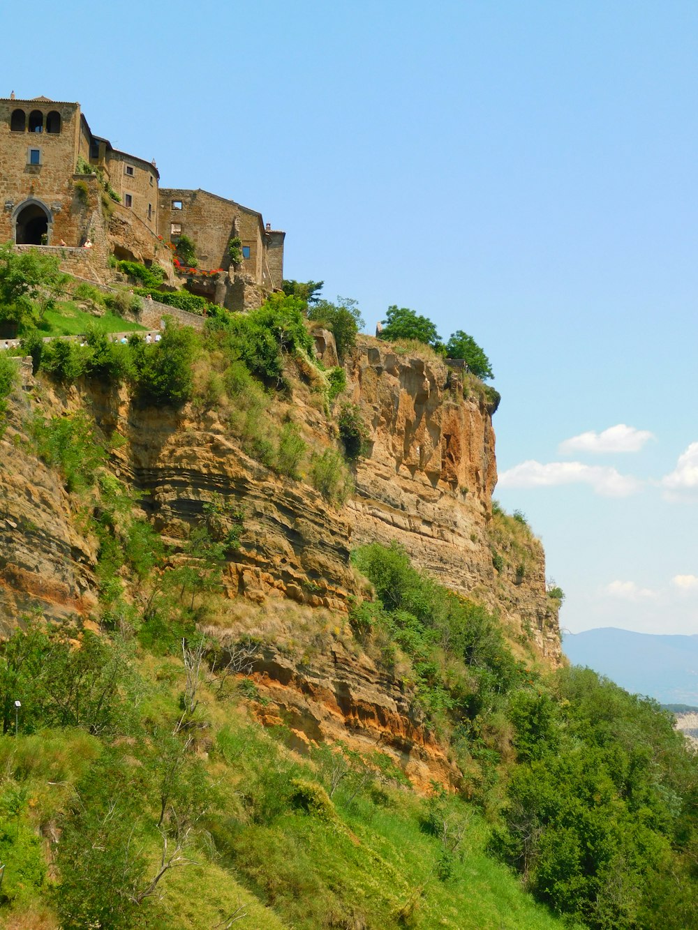 brown concrete building on cliff during daytime