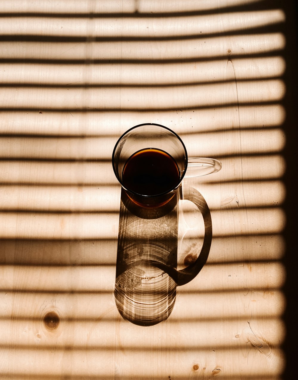 clear glass mug with brown liquid inside