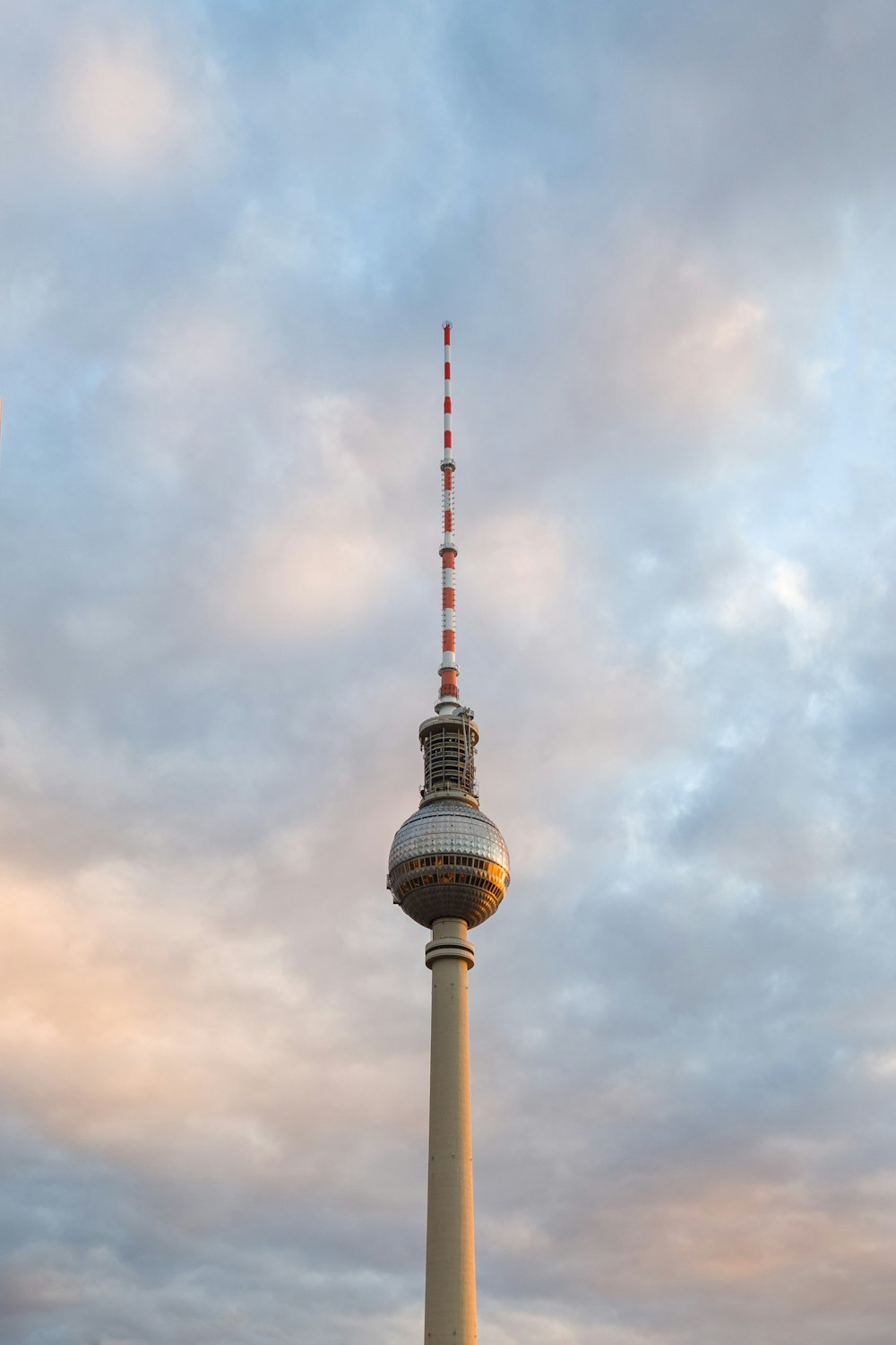 white and red tower under cloudy sky