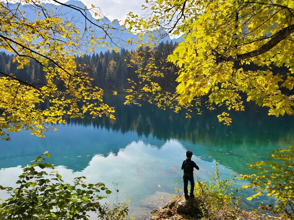 person in black jacket standing near body of water during daytime