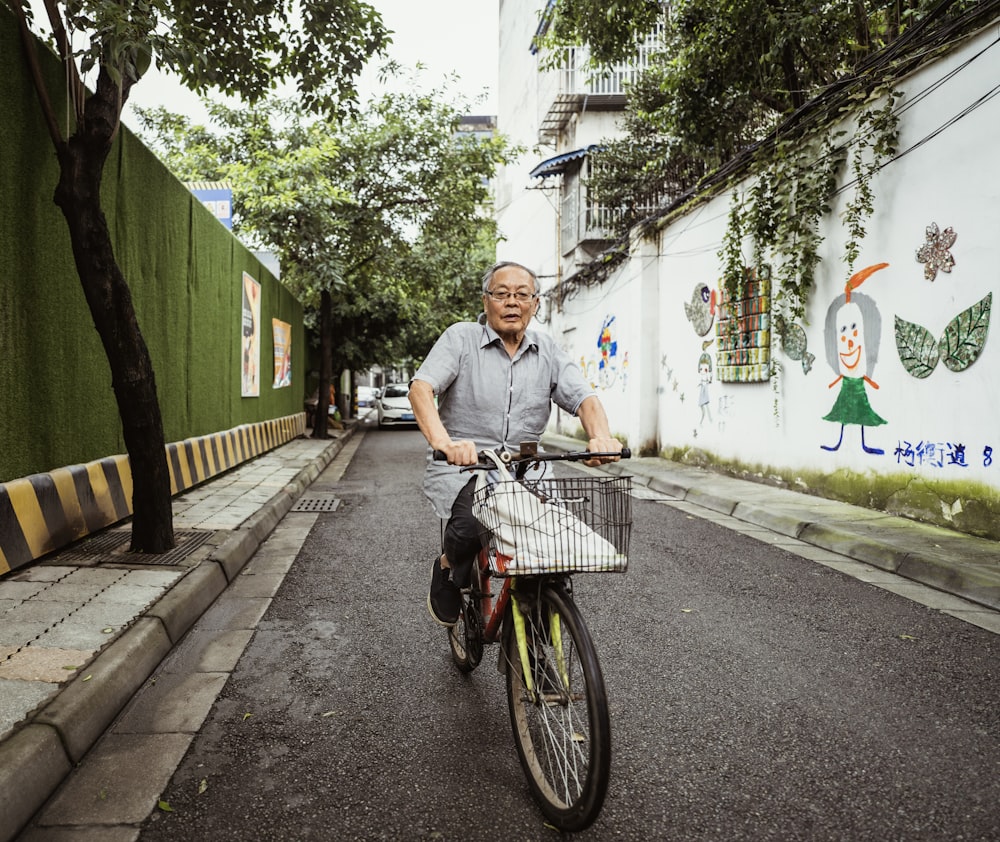 man in white t-shirt riding bicycle on road during daytime