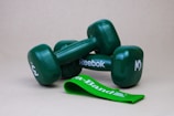 2 green dumbbells on white surface