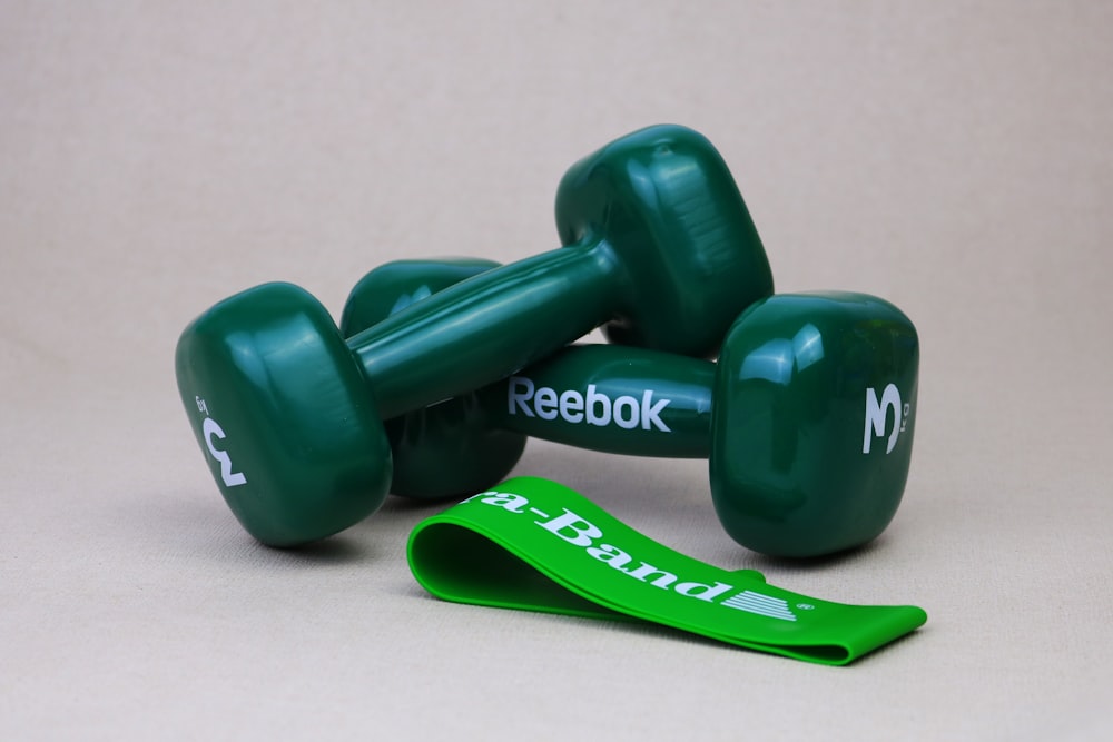 2 green dumbbells on white surface