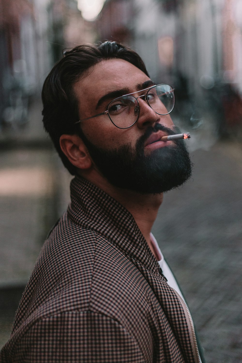 man in black and white checkered button up shirt smoking