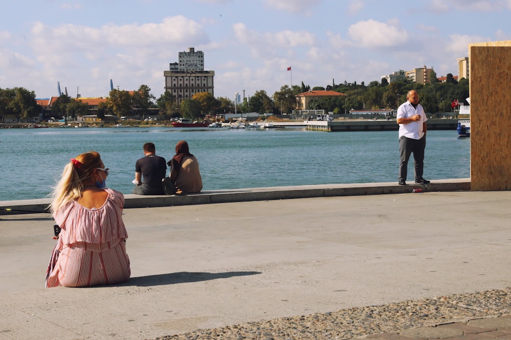 people sitting on gray concrete dock during daytime