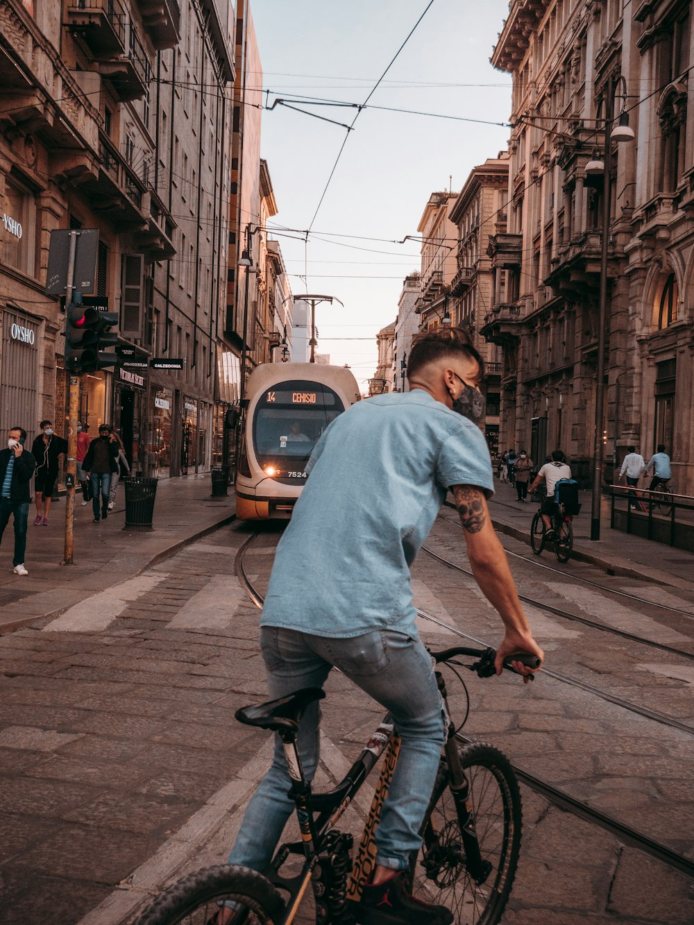 man in blue shirt riding bicycle on street during daytime