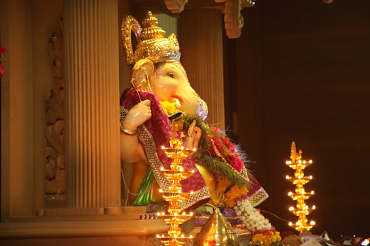 gold hindu deity figurine on brown wooden table in Thane West India