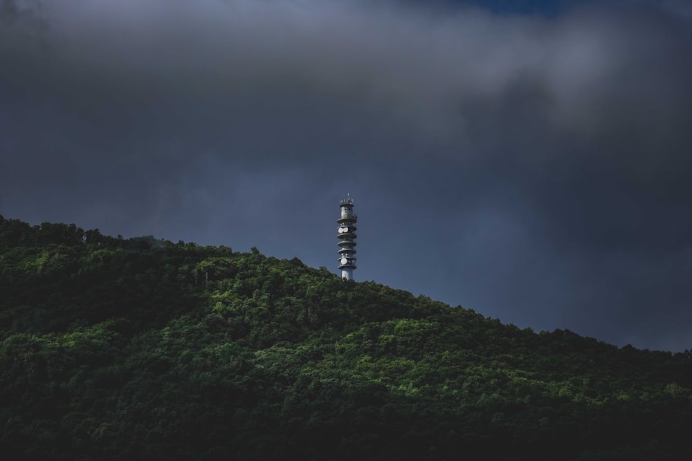 white and black lighthouse on top of mountain