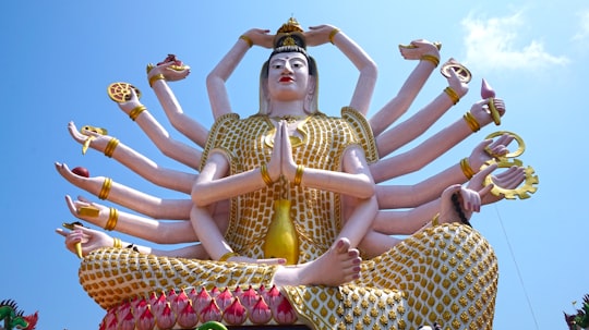 gold and white hindu deity statue in Wat Plai Laem Thailand