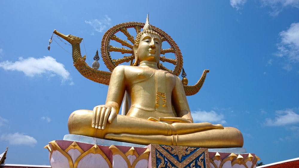 Estatua de Buda de oro bajo el cielo azul durante el día