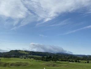 Scenic riverside course landscape with rolling greens under blue skies