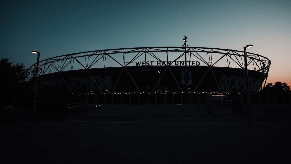 silhouette of people walking on bridge during night time